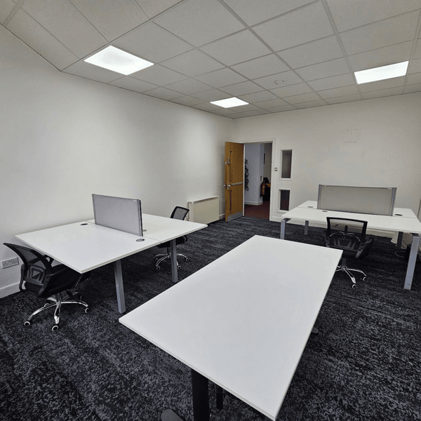 Method Spaces Unit 1A-101 features five desks, high ceilings, expansive windows, modern bathrooms, and a view of Portland Street in Manchester.