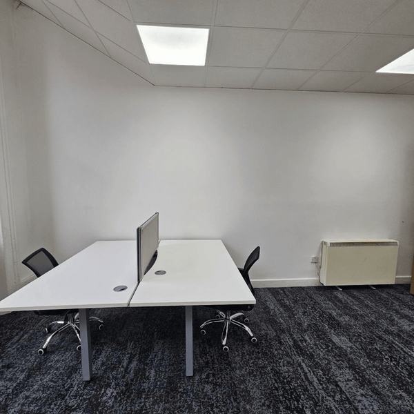 Method Spaces Office Unit 1A-101 offers five desks, high ceilings, natural light from large windows, renovated bathrooms, and street view of Portland St. Located at Portland Plaza, Manchester.