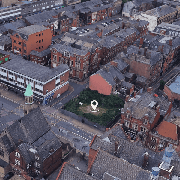 Aerial view of a city showcasing various buildings, prominently featuring a land development site in Bolton, Greater Manchester