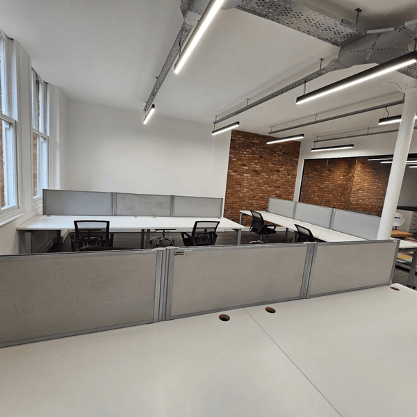 Bright and stylish Unit 309 in Manchester offers 16 desks, modern amenities, high ceilings, and a comfortable common area.