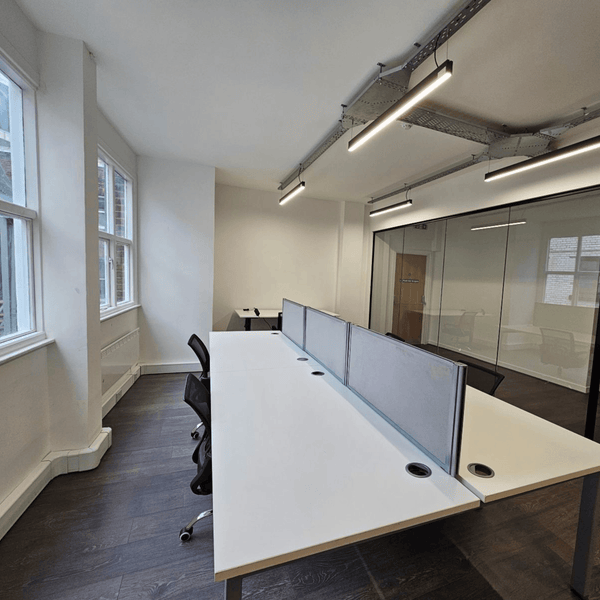 Bright and stylish Unit 311 in Manchester featuring seven desks, expansive windows, and a fully equipped kitchen for productivity.