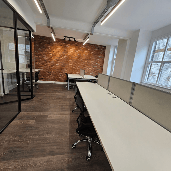 A stylish office unit in Manchester with natural light, seven desks, common area, and modern facilities for productivity.