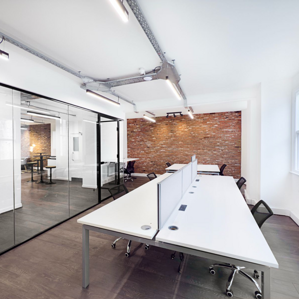 Modern serviced office for rent, equipped with ergonomic furniture, standing desks, and large windows for natural light.