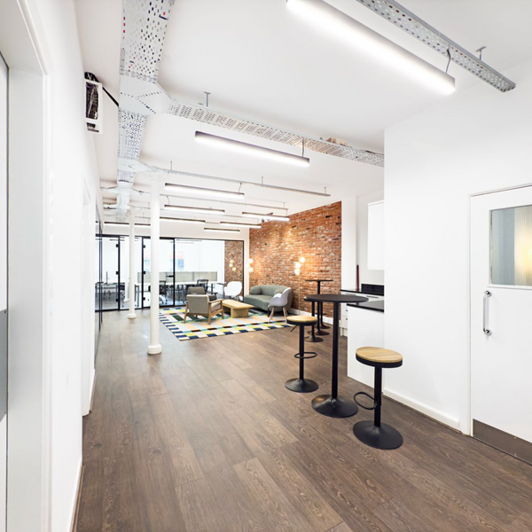 A well-lit, tidy and spacious kitchen and common area in a serviced office, featuring modern appliances furniture.