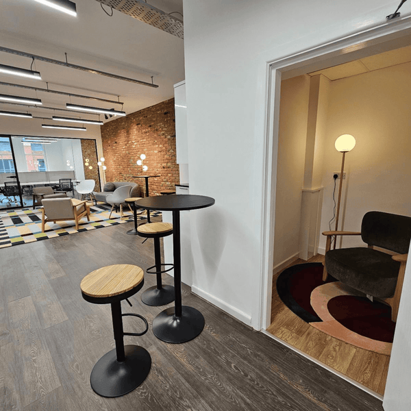 A break room in the serviced offices in Portland Plaza, Manchester, featuring a couch, chair, and table arranged for relaxation and collaboration, with fully equipped kitchen and meditation room.