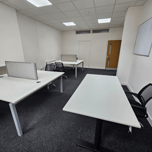 Five desks are arranged in Unit 114, a serviced office at 109 Portland St., Manchester.