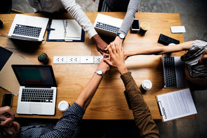 Business professionals collaborating at a table, each using laptops for a meeting or discussion.